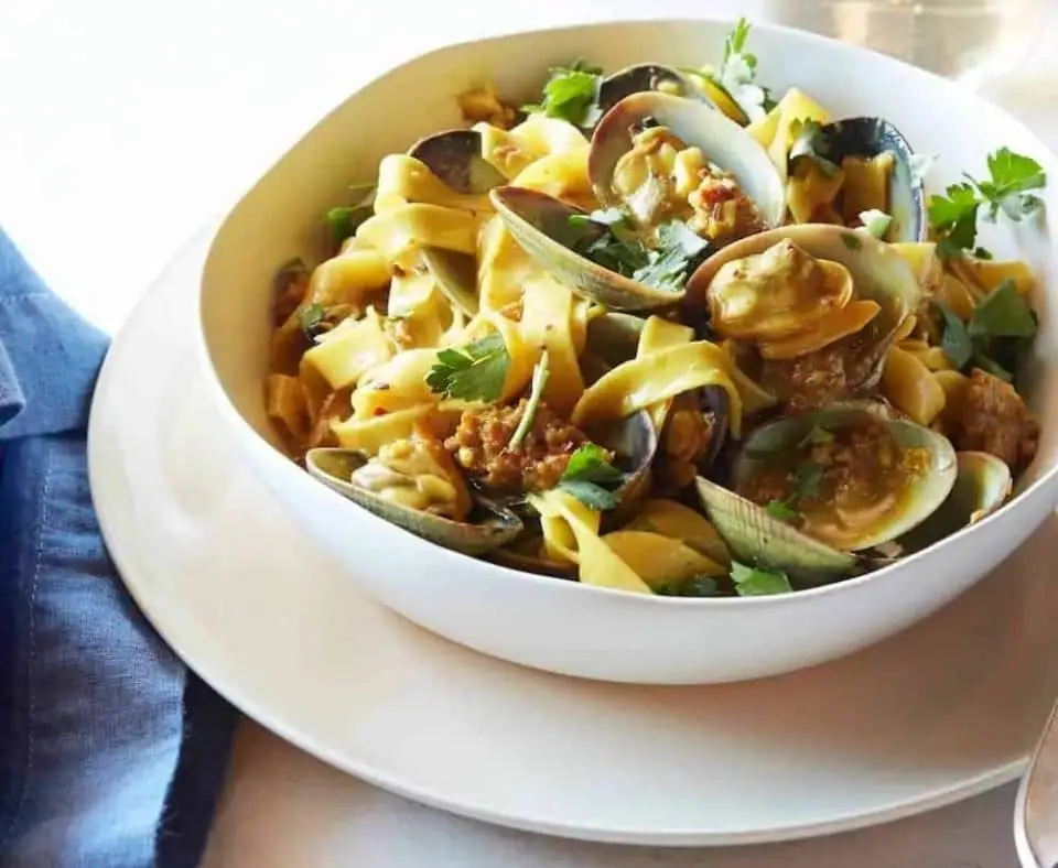 Fettuccine con almejas de Manila, salchicha picante y reducción de azafrán y vino blanco.
