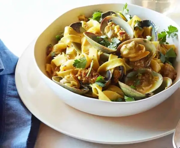 Fettuccine con almejas de Manila, salchicha picante y reducción de azafrán y vino blanco.