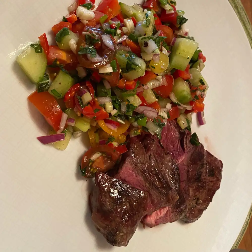 Hanging tender with Israeli tomato and cucumber salad