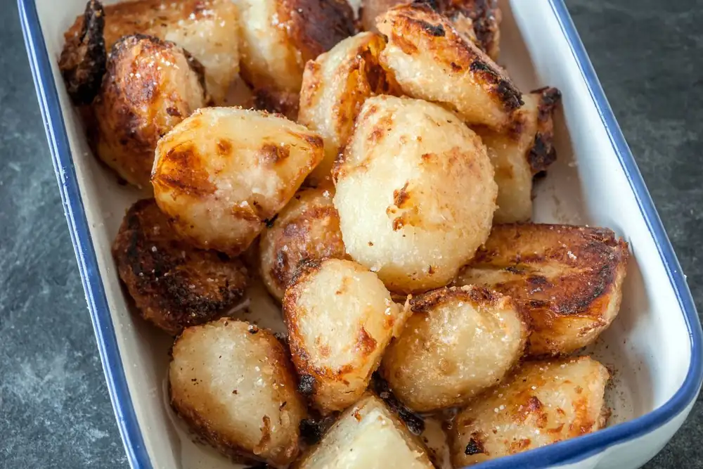 Las patatas asadas quedarán doradas si las rebozas con un ingrediente inusual antes de cocinarlas