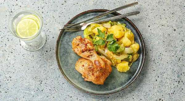 Chicken legs with mashed potatoes in a frying pan