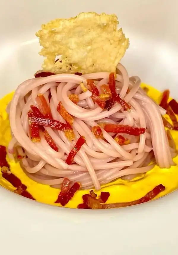 Spaghetti with purple cabbage, saffron cream, and crispy speck