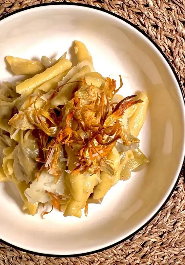 Garganelli, artichokes cooked in their broth, cream of stems and potatoes, pecorino flakes and artichoke chips