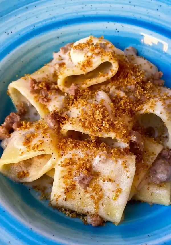 Paccheri with nutmeg-flavored parmesan cream, sausage crumbs, crispy breadcrumbs