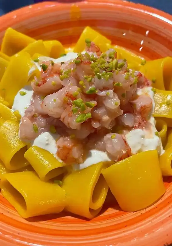Calamarata al azafrán con stracciatella, pistacho y tartar de gamba roja