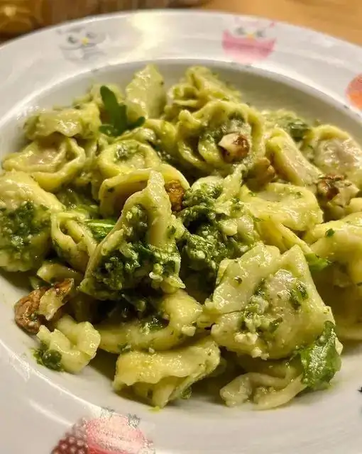Tortellini with raw ham and parmesan cheese with arugula pesto
