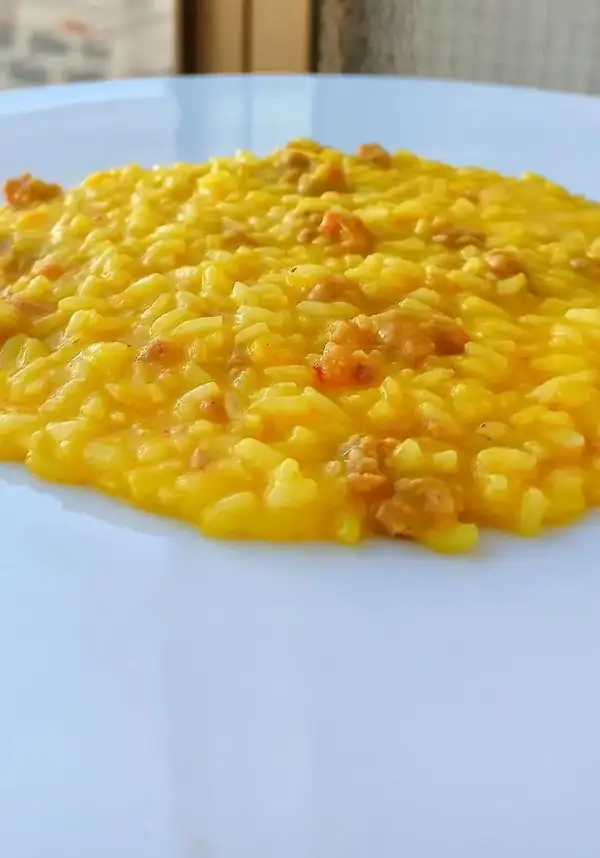 Risotto with raw ham and saffron sausage broth