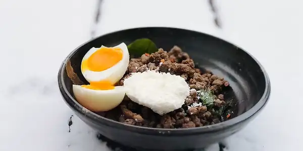 Carne picada con mantequilla y hojas frescas de curry