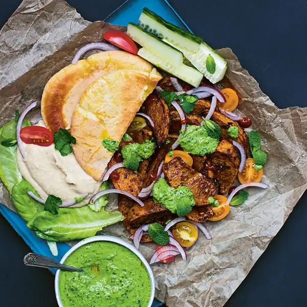 Shawarma roasted turnip in pita bread with hummus and green tahini sauce