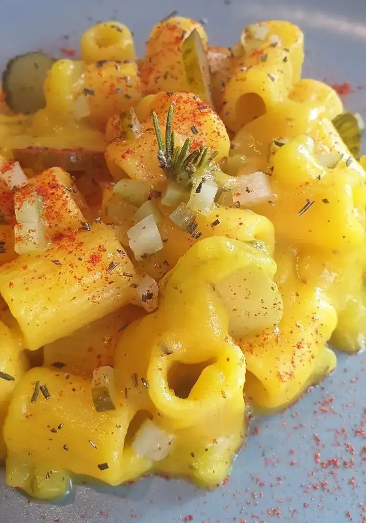 Mezzemaniche in saffron and rosemary cream with sweet and sour gherkins and tomato powder