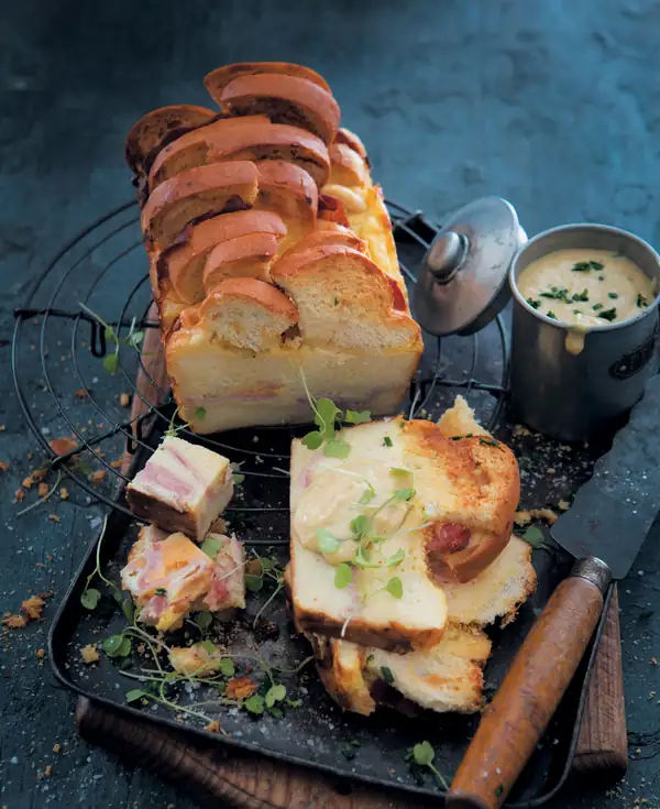 Croque-monsieur salado, pudín de pan y mantequilla con salsa de queso Cheddar