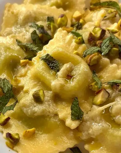 Raviolis de ricotta y hierbas con crema de alcachofa y pistachos picados