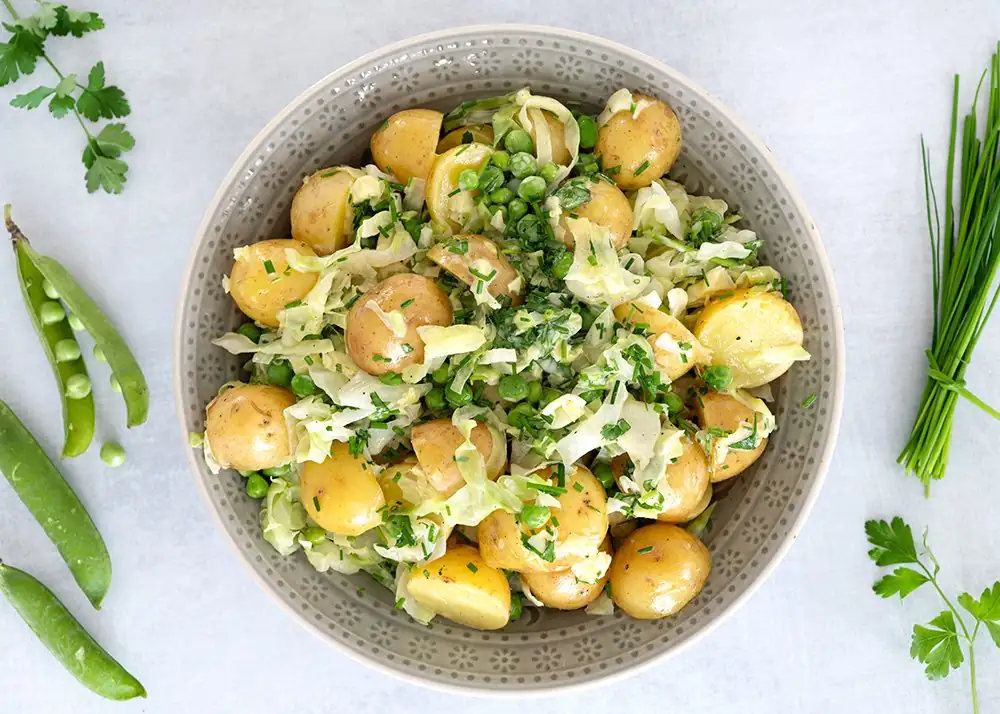 Warm potato salad with cabbage and peas