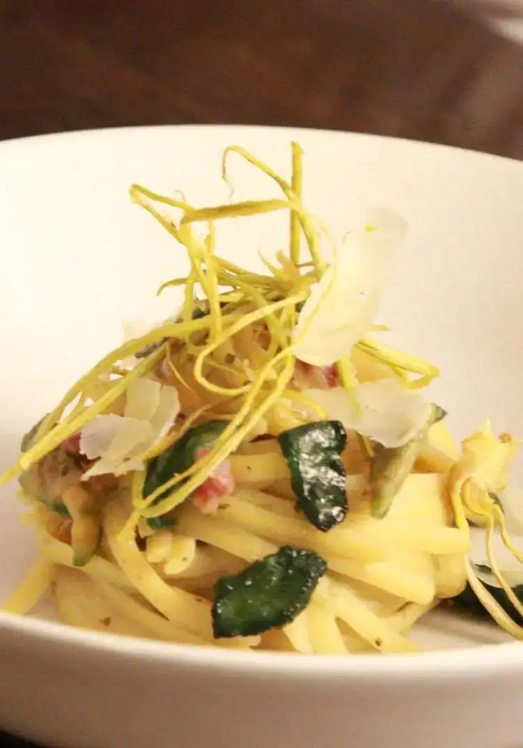 Linguine in creamed artichoke and potato sauce with chopped sausage, pecorino cheese puff pastry and artichoke chips