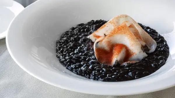 Rice with cuttlefish tartare, its ink, and roasted pepper powder: the recipe from Ristorante Olio