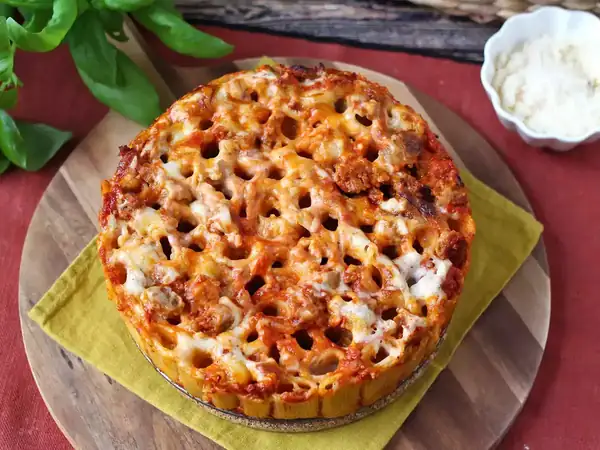 Timbal de rigatoni al horno con salchicha, salsa bechamel y mozzarella