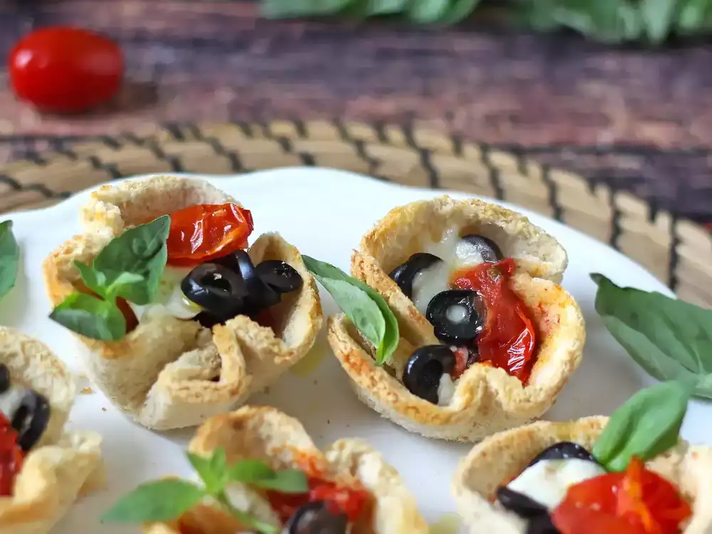 Baskets of sliced ​​bread filled with cheese, tomato and olives