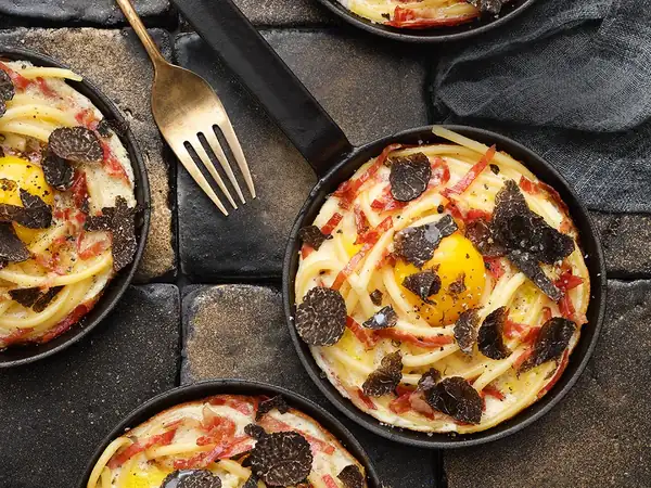 Macaroni and fried egg alla carbonara with black truffle