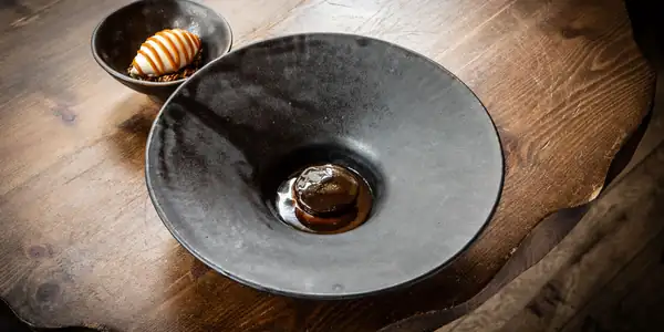 Receta de brownie de alcachofa de Jerusalén y chocolate, helado de avellana, crujiente de alcachofa de Jerusalén, caramelo y grosella negra