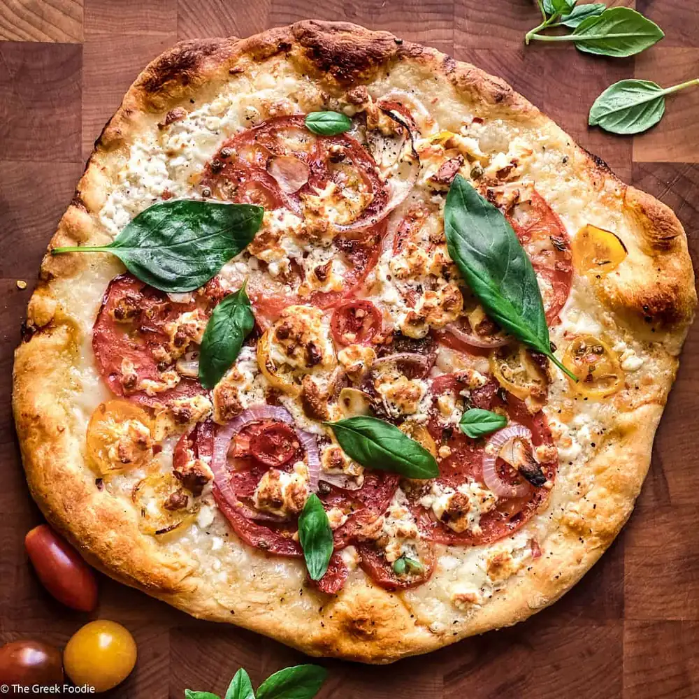 Pizza de queso feta con tomate y albahaca