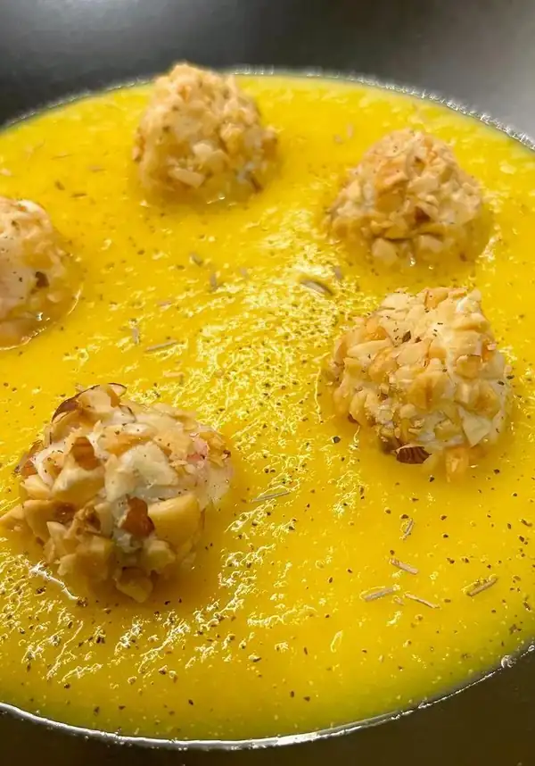 Gorgonzola and hazelnut truffles on a cream of yellow cauliflower and saffron
