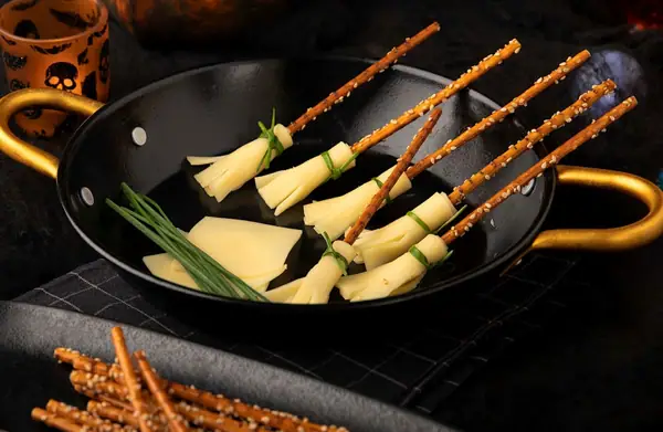 Escobas de pretzel con queso para Halloween