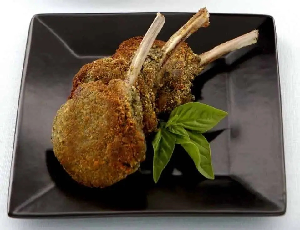 Chuletas de cordero con costra de pesto y caponata de berenjena y aceitunas